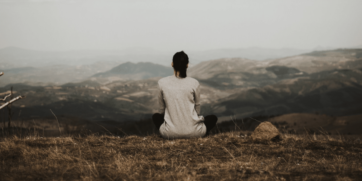 Image commercially licensed from: https://unsplash.com/photos/woman-sitting-on-cliff-overlooking-mountains-during-daytime-Zf0-90SpDD0